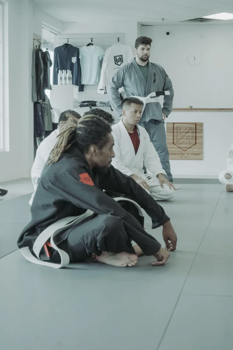 Gi class with instructor demonstrating technique