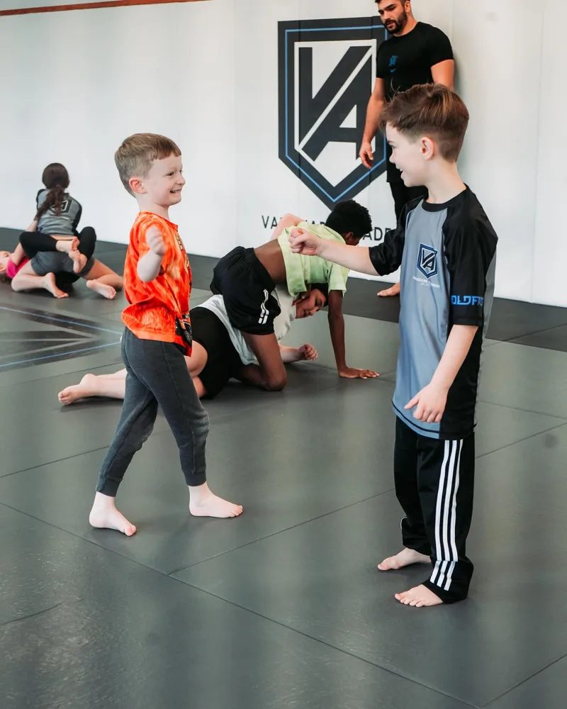 Kids fist-bumping with smiles at Vanguard Academy
